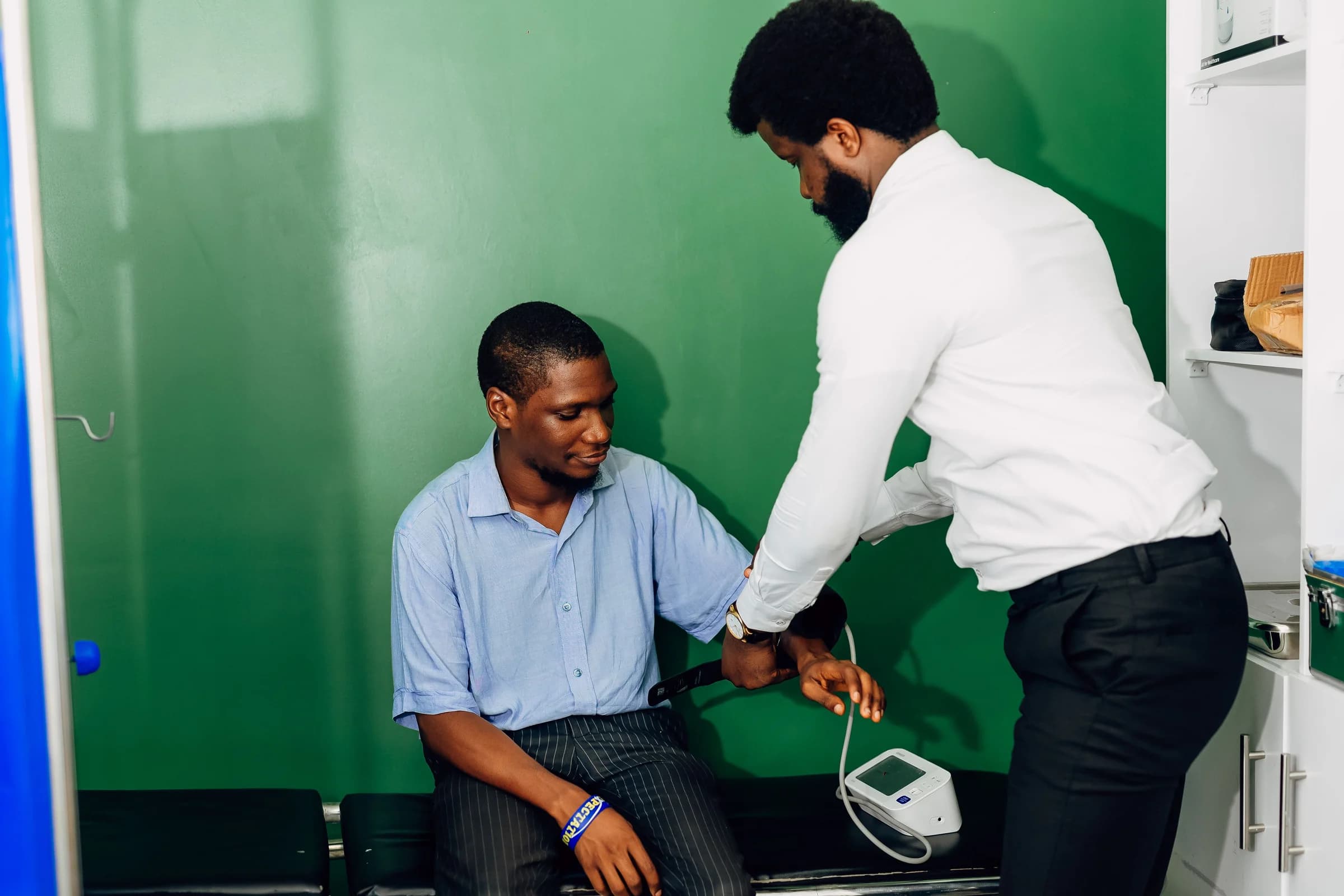 A healthcare professional taking a seated patient's blood pressure